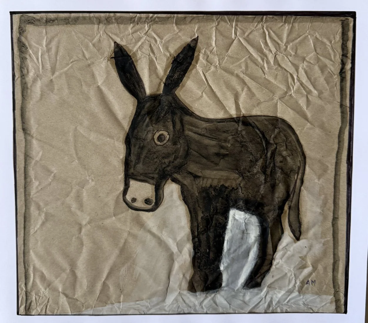 Âne brun de profil à la patte blanche, sur un papier froissé couleur de terre