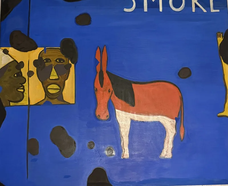 Âne rouge à crinière noire sur fond bleu profond, entouré de deux figures encapuchonnées
