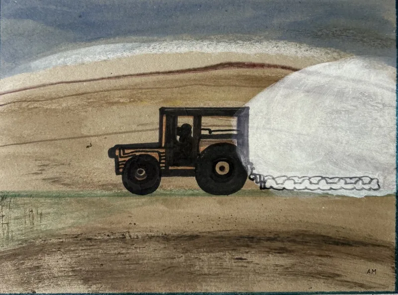 Tracteur sombre tirant une grosse balle de paille blanche sur un champ tan sous ciel bas